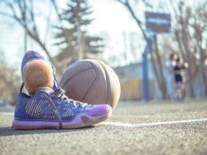 Ein Basketball und Basketballschuhe liegen auf einem Freiplatz